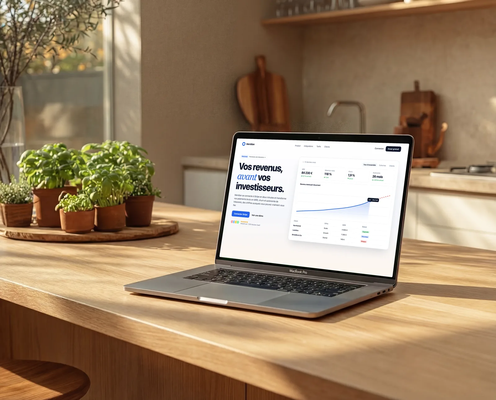 MacBook Pro sur un îlot de cuisine en bois, à côté d'herbes aromatiques en pot dans la lumière du matin, affichant un tableau de bord SaaS