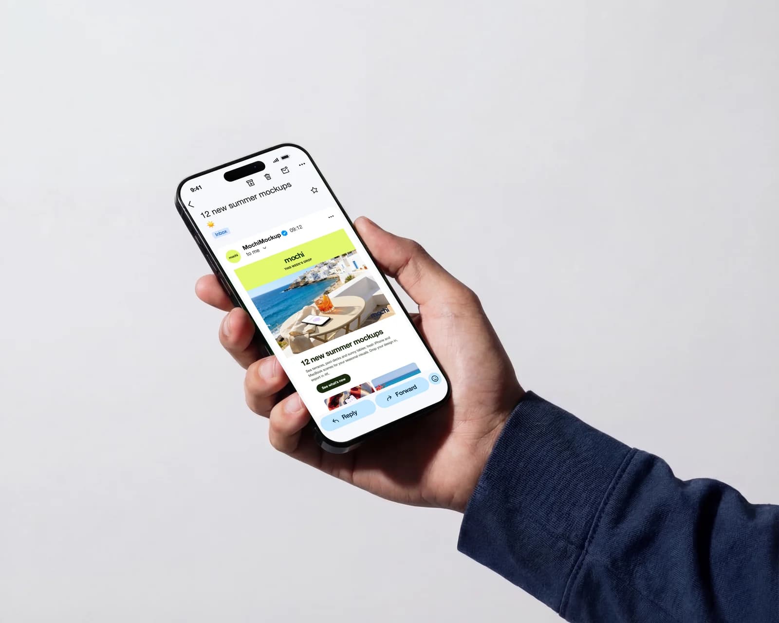Hand holding an iPhone that shows a MochiMockup newsletter opened in the Gmail app, subject “12 new summer mockups”