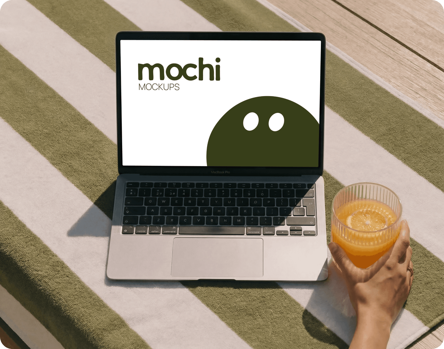 MacBook showing a MochiMockup design on a striped blanket